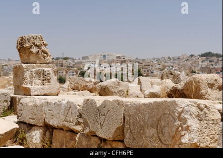 Jerash. Jordanien. Ansicht der alten griechischen Schrift eingeschrieben Steinmauer an der antiken Stadt. Im Hintergrund ist die moderne Stadt Stockfoto