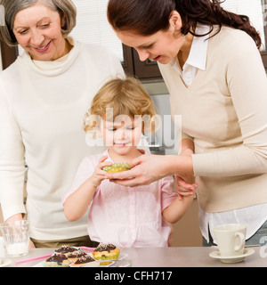 Drei Generationen Frauen auf Cupcake Mädchen Verkostung Cookies Stockfoto