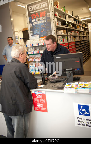 Assistentin für einen Kunden an einem Seitenarm des Bauherren Lieferanten und Händlern SCREWFIX, UK Stockfoto