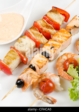 Nahaufnahme von gegrillten Lachs und Garnelen mit Tomaten und Paprika auf Bambusstäbchen Stockfoto