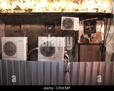 eine Sammlung von alten Ventilatoren und Klimaanlagen auf einer Wand Stockfoto