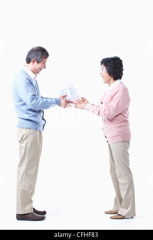 Ein älterer Mann, der die Gabe für eine ältere Frau Stockfoto