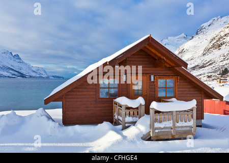 Verschneite Hütte Californias in norwegischer Fjord Dorf von Ersfjord, Kvaloya Insel, Troms, Norwegen, Europa Stockfoto