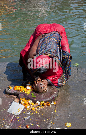 Frau vor einem Shiva Lingam niederwerfen. Godavari Fluß. Nasik. Indien Stockfoto