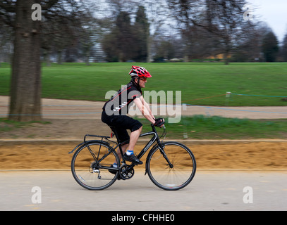 Ein Radfahrer, der durch den Hyde Park in London in Großbritannien reitet. Stockfoto