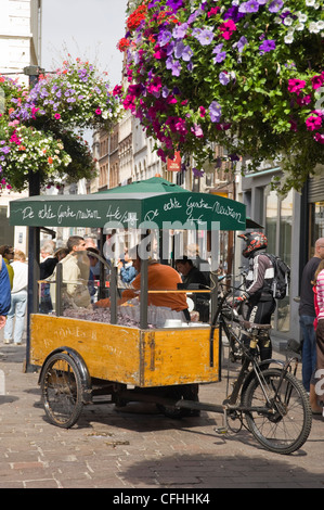 Vertikale Nahaufnahme von einem Fahrrad Warenkorb Verkauf von traditionellen Süßigkeiten, cuberdons, Leute auf der Straße in Gent, Belgien Stockfoto