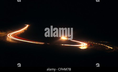 Lichtspuren auf Bergstraße. Langzeitbelichtung. Stockfoto