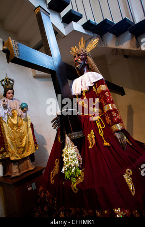 Eine Statue des schwarzen Nazareners sitzt im Inneren der Kathedrale von Antipolo in der Rizal-Provinz der exotischen philippinischen Inseln. Stockfoto