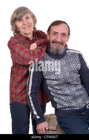 glückliches Ehepaar im Ruhestand lässig gekleidet Landhausstil auf weißem Hintergrund mit dem Mann sitzt auf einem Fass Stockfoto