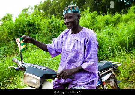 Ein muslimischer Beninese Mann trug ein traditionellen Batik-Hemd und eine bunte Mütze. Stockfoto