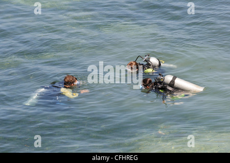 Offenes Wasser Tauchlehrer führen einen Tauchkurs in flachen Freiwasser mit zwei interracial Studentinnen Stockfoto