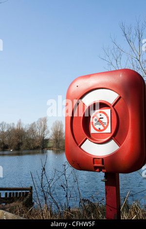 Roten lebensrettende Ausrüstung mit einem kein Schwimmen-Schild neben einem Teich/See Northamptonshire, England, UK Stockfoto