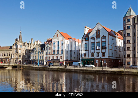 Das Ufer im schottischen Leith Docks Edinburgh mit Water of Leith und Restaurants in den Häusern entlang der Dock-Seite. Stockfoto