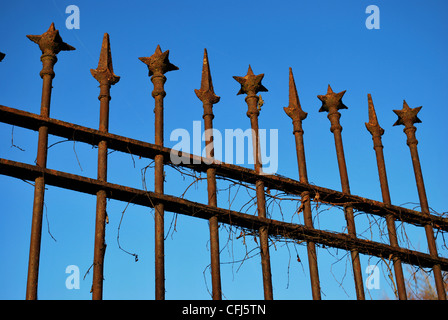 Alte schmiedeeiserne rostige Geländer gegen blauen Himmel Stockfoto