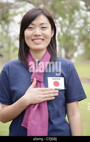 Junge Frau, die Unterstützung der Japan-Frauen-Fußball-Nationalmannschaft Stockfoto