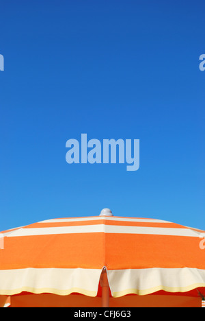 Orange gestreift Sonnenschirm über blauer Himmel, freier Raum für Text, Rimini, Italien Stockfoto