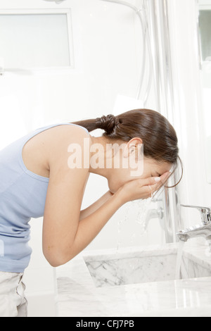 Junge Frau waschen Gesicht Stockfoto