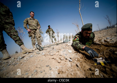 KANDAHAR, Afghanistan - Fakhr Uddin, ein afghanischer Soldat der Nationalen Armee, trainiert während der Kampfeinsatz gegen IED, während Senior Airman Lee McLean, 966. Sprengstoff-Entsorgungs-Flug Operating Location-Bravo Partnership-Mitglied, am 13. März schaut. Sprengstoffentsorgung die dem 96th EOD Operating Location-Bravo Zug zugewiesenen Airmen betreuen und validieren anschließend die ANA EOD Techniker. Stockfoto