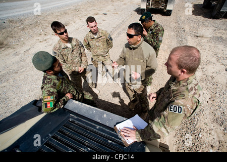 : KANDAHAR, Afghanistan - Staff Sgt. Dave Hewitt (ganz rechts), 96th Explosive Ordnance Disposal Flight Operating Location-Bravo Partnership Team Leader, derebrieft Fakhr Uddin (ganz links) nach der Praxis Gegeneinsätzen im März 13. Die dem Team der OL-B-Gruppe zugewiesenen Piloten sind Mentor und validieren anschließend die EOD-Techniker der afghanischen Nationalarmee. Stockfoto