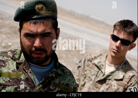 KANDAHAR, Afghanistan - Fakhr Uddin (links), ein afghanischer Soldat der Nationalen Armee, nimmt an einer Nachbesprechung Teil, nachdem er während der Staff Sgt. Kenneth Guinn, 96th Explosive Ordnance Disposal Flight Operating Location-Bravo Partnership Team Mitglied, schaut auf März 13. Die dem Partnerschaftsteam zugewiesenen Piloten trainieren, betreuen und validieren anschließend die ANA EOD Techniker. Stockfoto