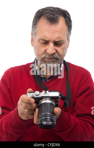 Porträt eines Reifen Mannes, der eine kleine spiegellose Kamera auf weißem Hintergrund hält Stockfoto