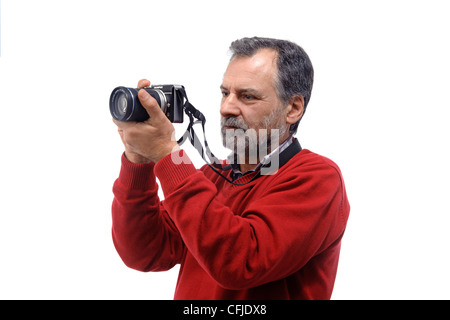 Porträt eines Reifen Mannes, der Fotos mit einer kleinen spiegellosen Kamera auf weißem Hintergrund macht Stockfoto