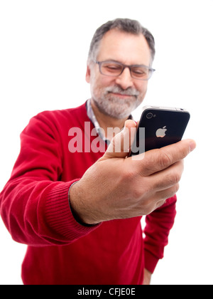 Mann mittleren Alters halten iPhone isoliert auf weißem Hintergrund Stockfoto
