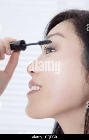 Junge Frau auf Wimperntusche Stockfoto