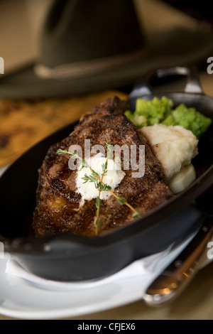 Knisternde t-Bone Steak serviert aus Gusseisen mit Kartoffelpüree und Brokkoli Stockfoto