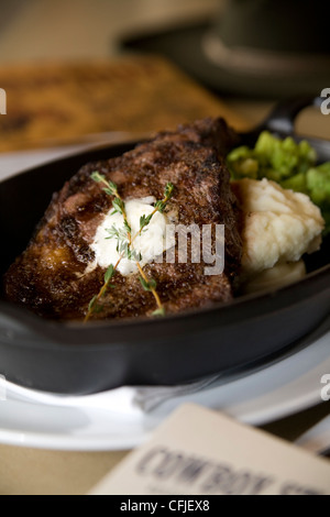 Knisternde t-Bone Steak serviert aus Gusseisen mit Kartoffelpüree und Brokkoli Stockfoto