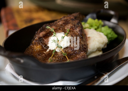 Knisternde t-Bone Steak serviert aus Gusseisen mit Kartoffelpüree und Brokkoli Stockfoto