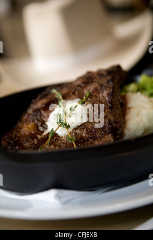 Knisternde t-Bone Steak serviert aus Gusseisen mit Kartoffelpüree und Brokkoli Stockfoto