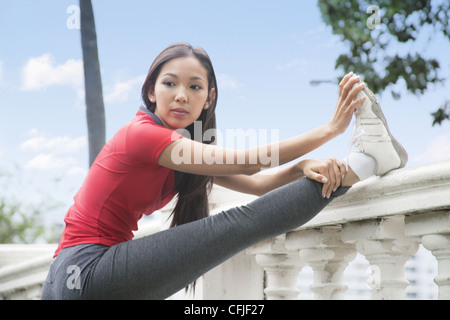Junge Frau, die Dehnung Stockfoto