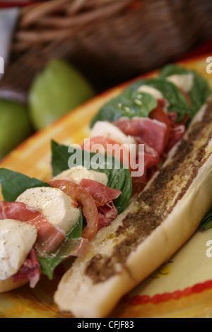 Tomaten-Caprese-Salat-Sandwich mit Mozzarella und Basilikum Blätter auf eine in Scheiben geschnittene baguette Stockfoto