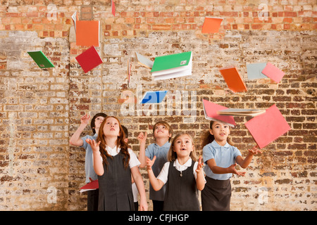 Kinder, die Bücher zu werfen, in der Luft Stockfoto