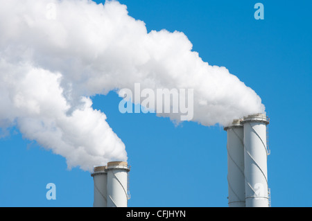 Rauchen Schornsteine aus einem Kraftwerk vor blauem Himmel Stockfoto