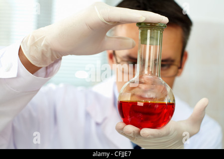 Nahaufnahme der Kolben mit roter Flüssigkeit in Händen der Wissenschaftler Stockfoto