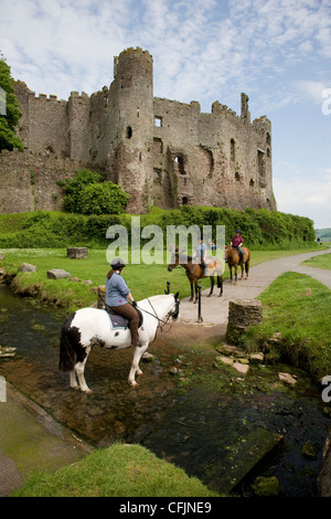 Reiter und Pony-trekking über einen Bach in Laugharne, Camarthenshire, Wales Stockfoto