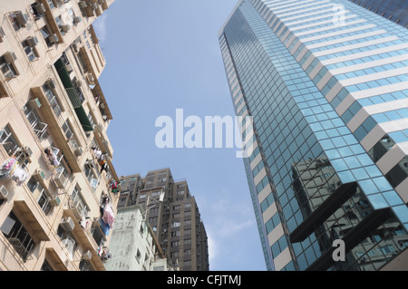 Stadt-Kontrast: eine alte Wohngebäude und ein modernes Büro tower in Hongkong Stockfoto