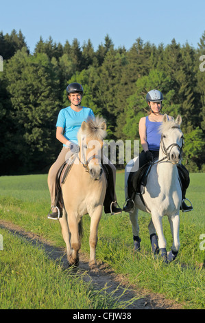 Zwei Mädchen reiten auf Rückseite des Ponys Stockfoto
