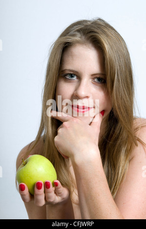 Attraktive junge kaukasischen Frau lächelnd Holding Apfel Stockfoto