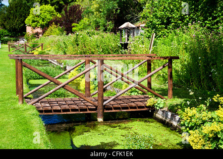 Eine ornamentale Rill und Holzsteg in den englischen Garten der Rasenflächen Landsitz in Berkshire, England, UK Stockfoto