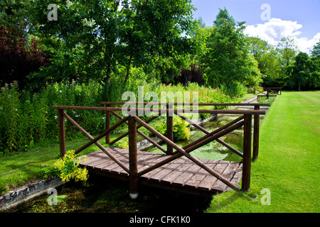 Eine ornamentale Rill und Holzsteg in den englischen Garten der Rasenflächen Landsitz in Berkshire, England, UK Stockfoto