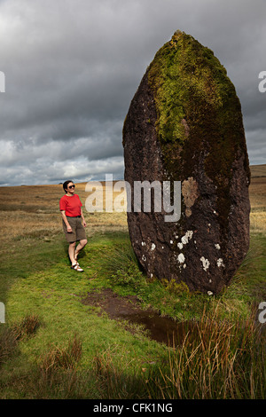 Person, die neben Maen Llia stehend Stein, Brecon Beacons National Park, Powys, Wales, UK Stockfoto