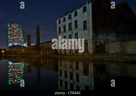 Bridgewater Place (aka The Dalek) spiegelt sich in der Leeds, Liverpool Canal in der Nacht Stockfoto