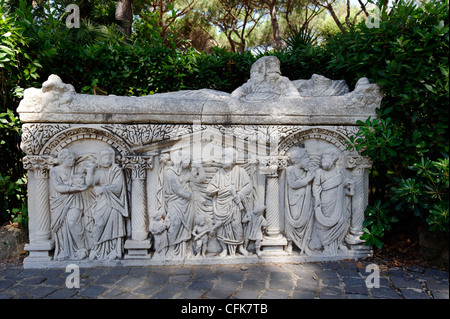 Ostia Antica. Lazio Rom. Italien. Blick auf einen reich verzierten Marmorsarkophag mit drei komplizierte menschliche Figur Szenen durch Spalten voneinander getrennt. Stockfoto