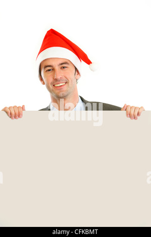 Lächelnder Mann in Weihnachtsmütze mit leeren Plakatwand isoliert auf weiss Stockfoto