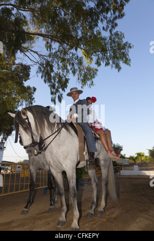 Spanischer Reiter mit Frau Reiten Sozius auf einem grauen andalusische Pferd. Stockfoto