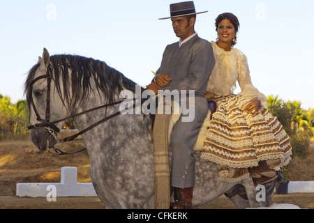 Spanischer Reiter mit Frau Reiten Sozius auf einem grauen andalusische Pferd. Stockfoto