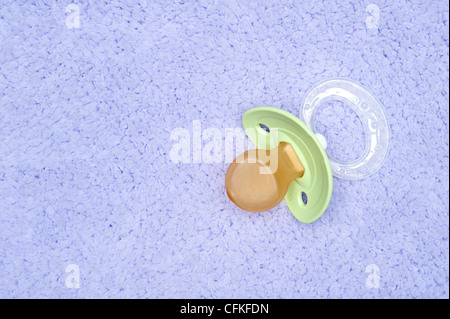 Ein Säugling Schnuller auf eine lila Decke. Raum bleibt für die Platzierung der Kopie. Stockfoto